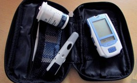Svart liten väska med blodsockermätare, insulinpenna och medicinburk