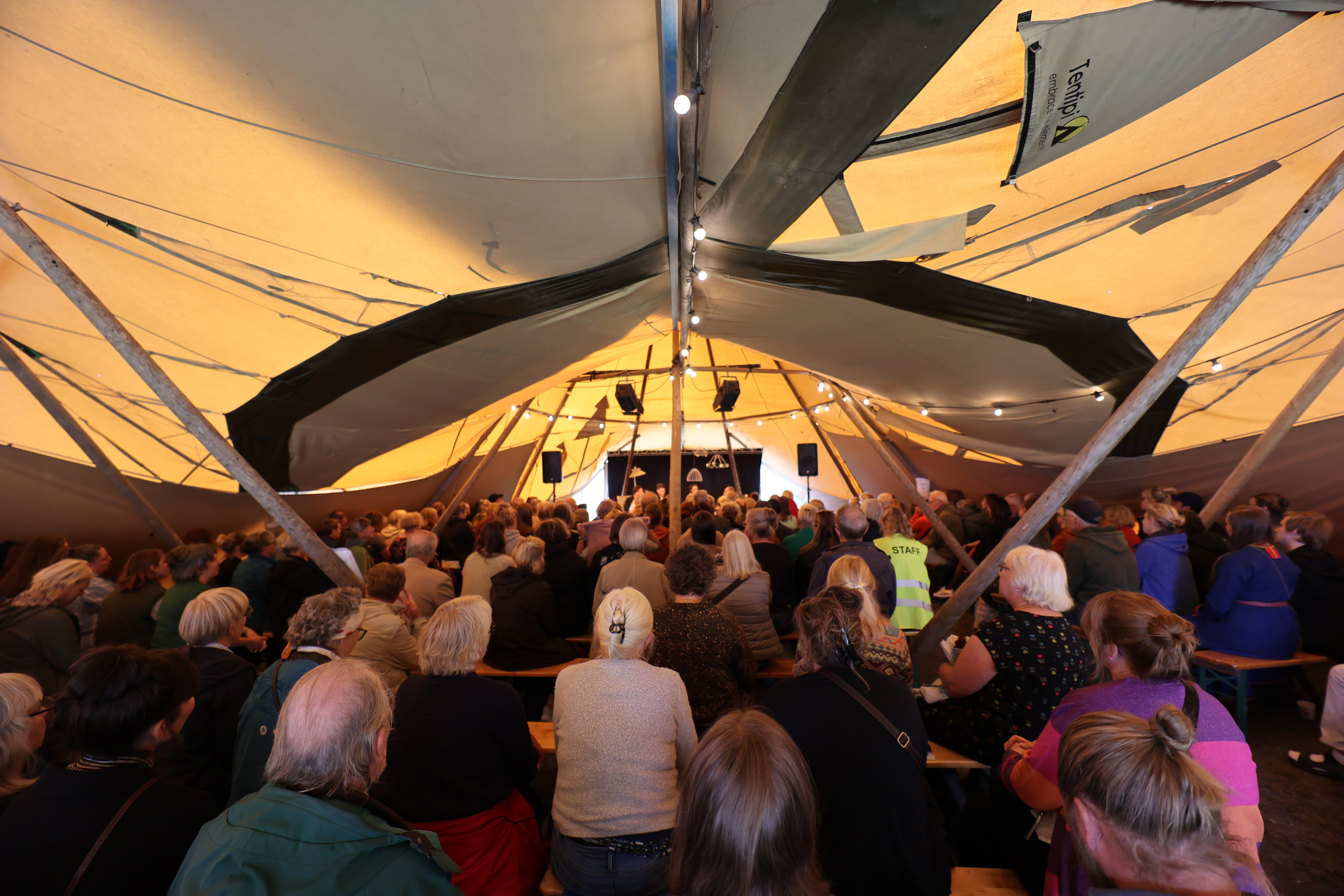 Stort tält fullt med folk, som lyssnar på författare på scen.