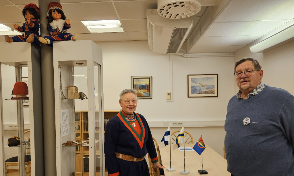 Birgitta Ricklund och Christer Jansson i samlingslokalen. Där står också glasmontrar med innehåll från deras olika kulturer.
