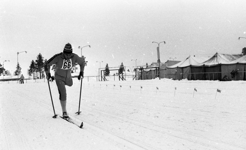 Skidåkare med amputerat ben i skidspåret. Tält till höger i bild.