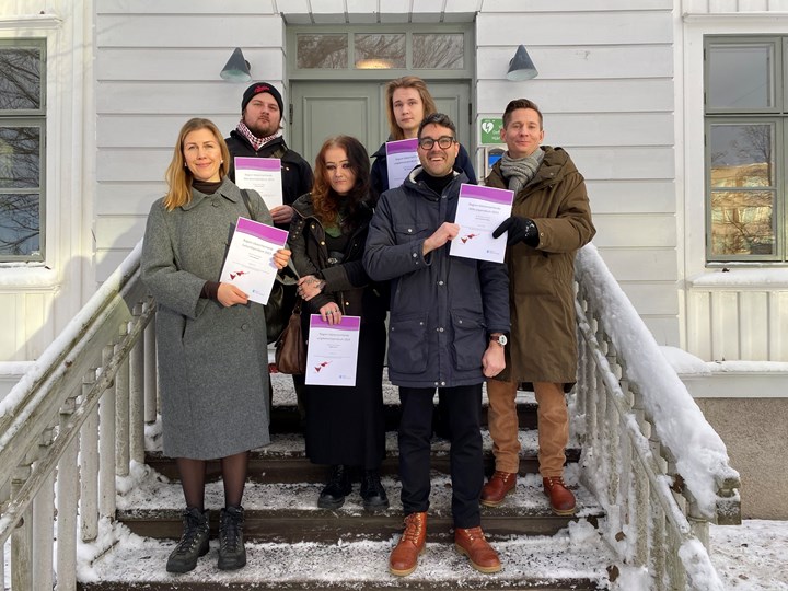 Sex kulturstipendiater står i en trappa som är snöig.