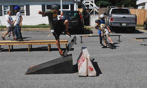 En bana för skateboard på asfalt med två barn som åker i banan.