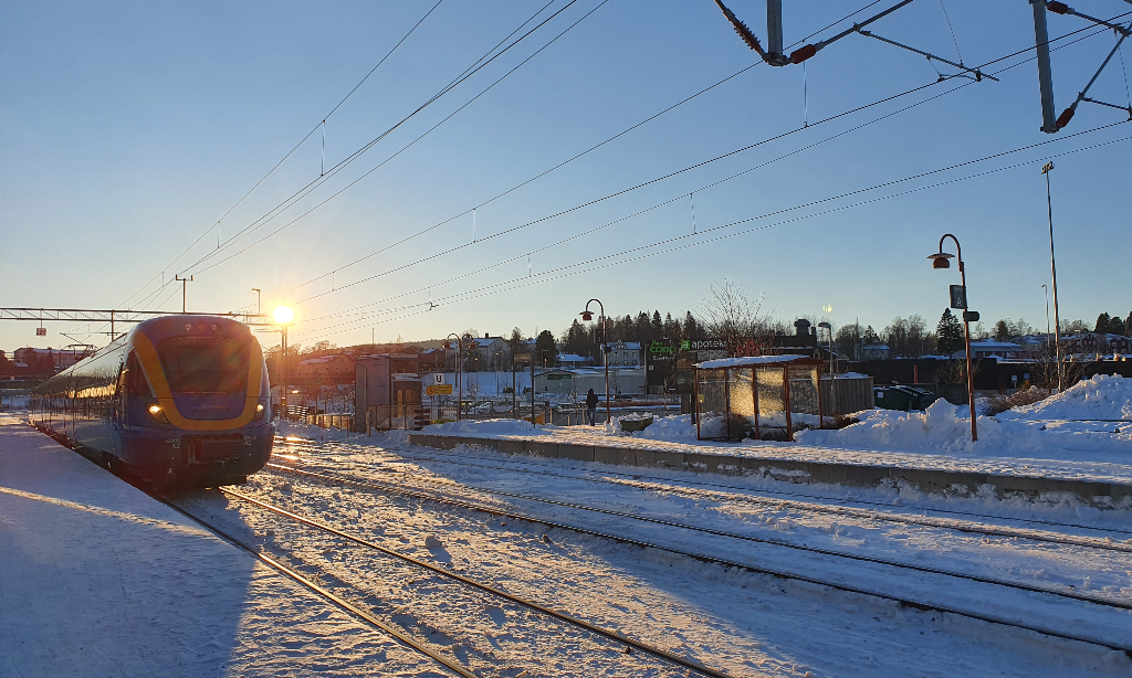Norrtåg som kommer in till perrongen i Timrå. Vinter och solen är på väg ner.